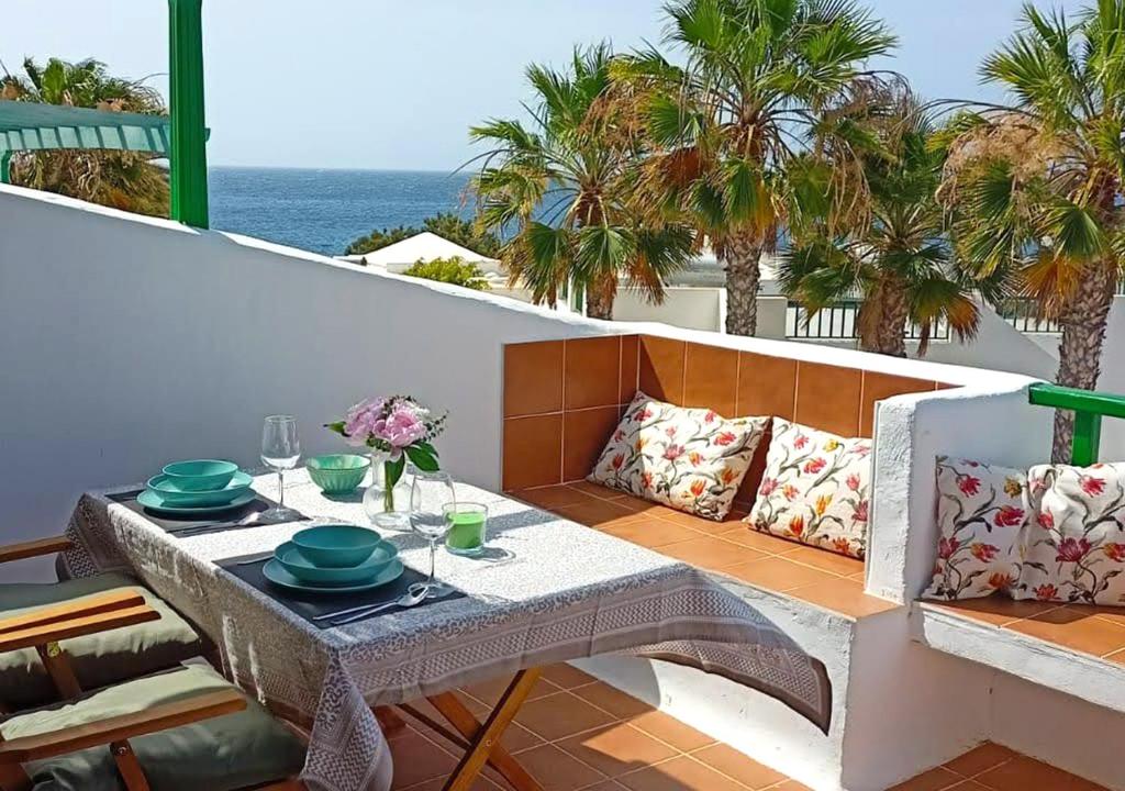 un tavolo su un balcone con vista sull'oceano di Calypso, apartamento completo con vistas al mar y a la piscina en Costa Teguise a Costa Teguise