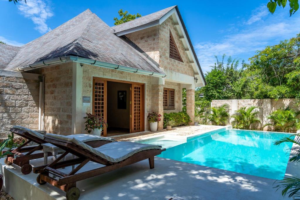 a villa with a swimming pool and a house at private pool cottage diani beach in Diani Beach