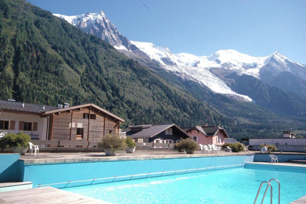 una gran piscina con montañas en el fondo en Modern Studio With Mont Blanc View And Pool, en Chamonix-Mont-Blanc