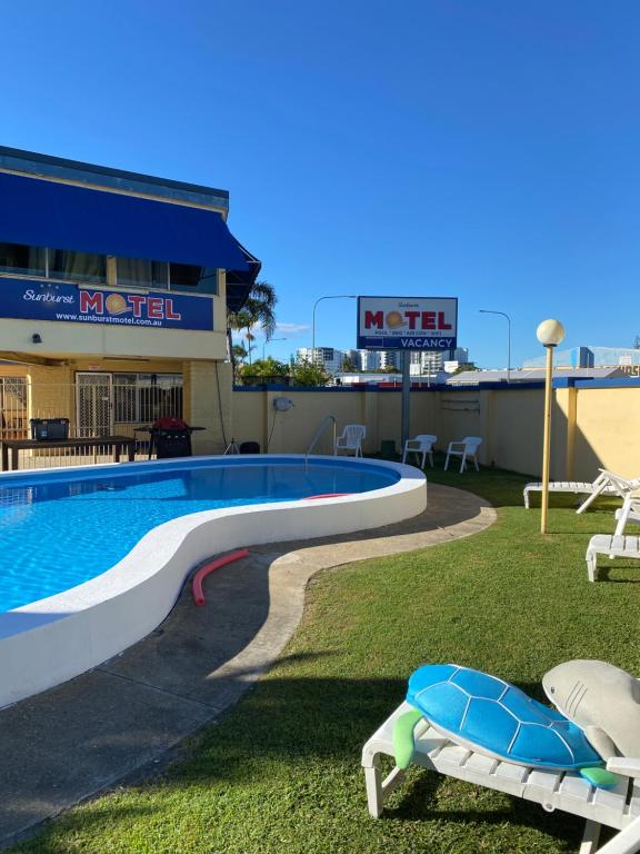 a pool on the roof of a building with two chairs at Sunburst Motel in Gold Coast