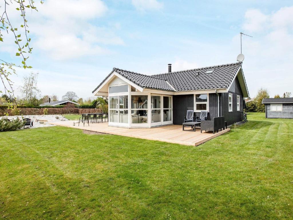 a house with a large deck in a yard at 6 person holiday home in V ggerl se in Bøtø By