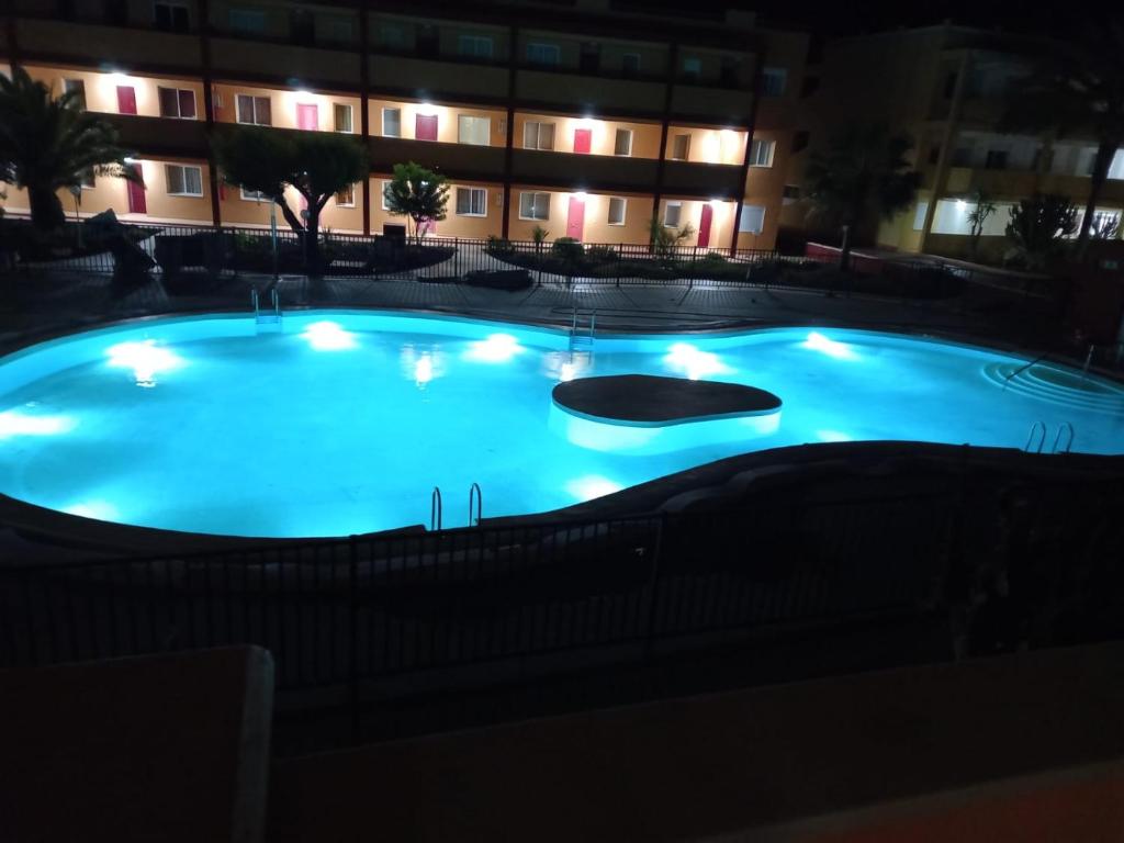 una gran piscina por la noche frente a un edificio en la Caleta Casa del Sole, en Parque Holandes