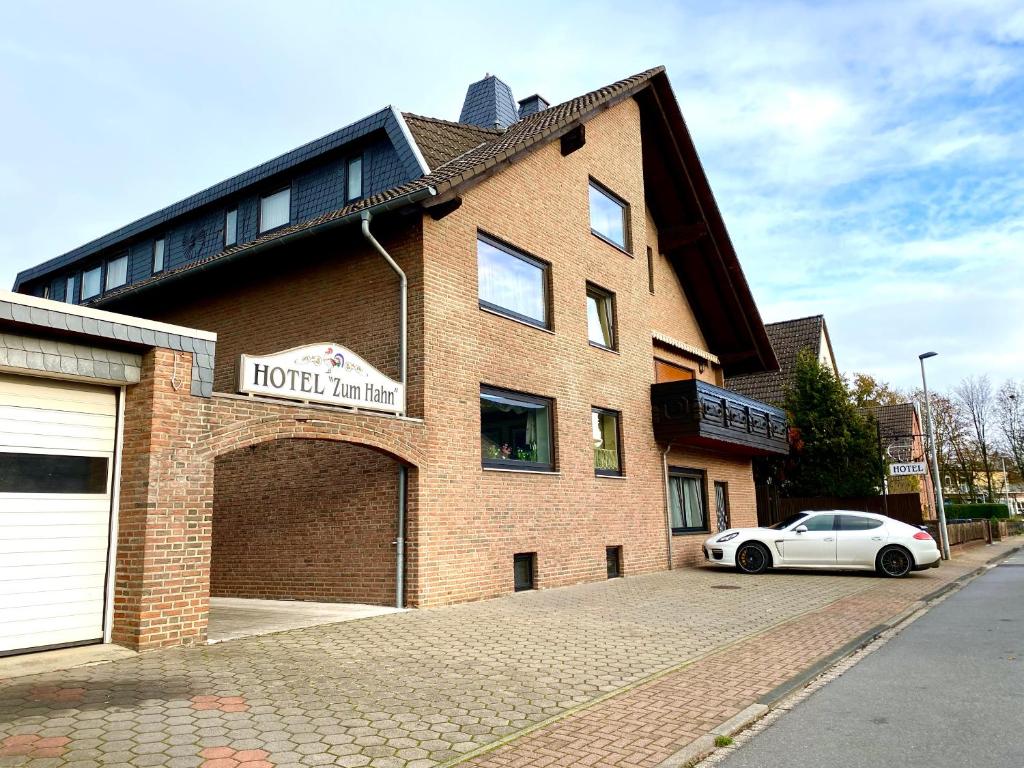 a brick building with a car parked in front of it at Hotel zum Hahn in Garbsen