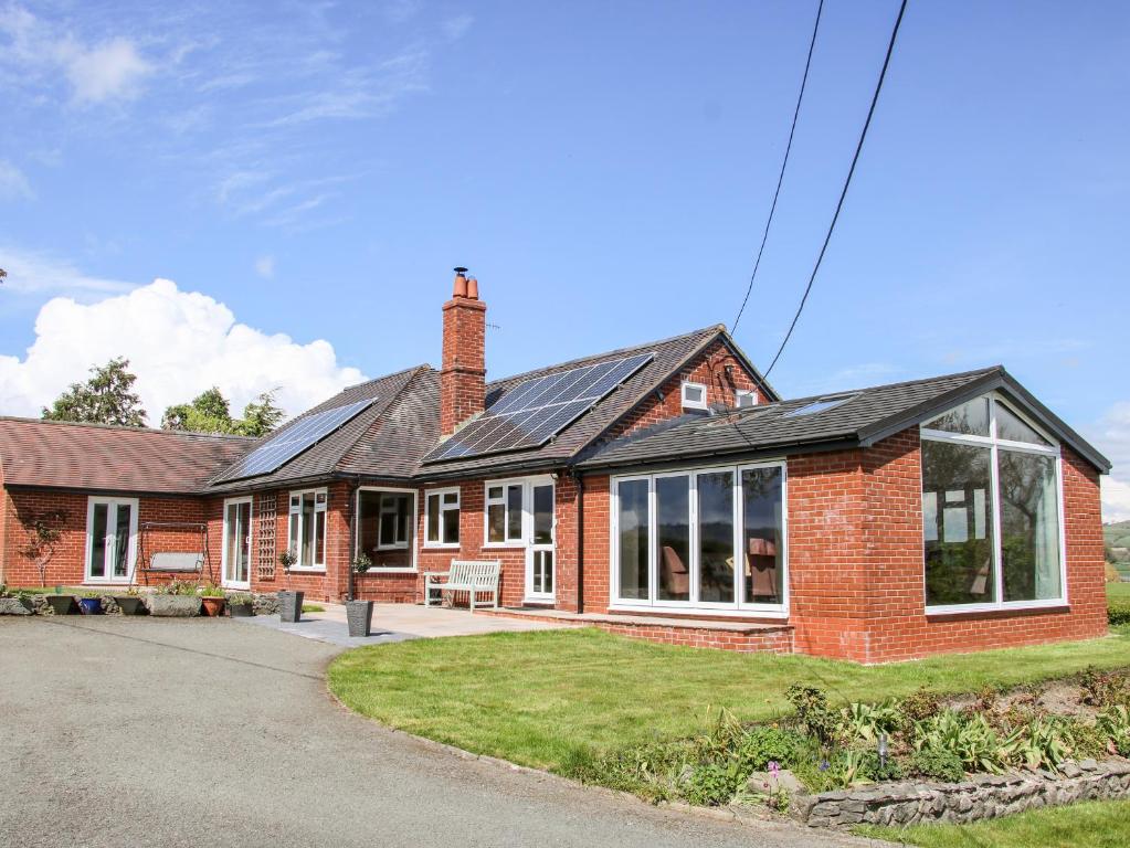 a red brick house with a lot of windows at Bryn Caer in Chirbury