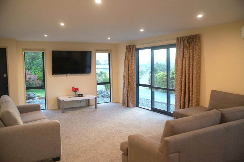 A seating area at Large Group Greymouth accommodation. 2 Adjacent houses with outdoor hot tub, 7 bedrooms, 6 queens & 6 single beds 3 bathrooms, 3 toilets.