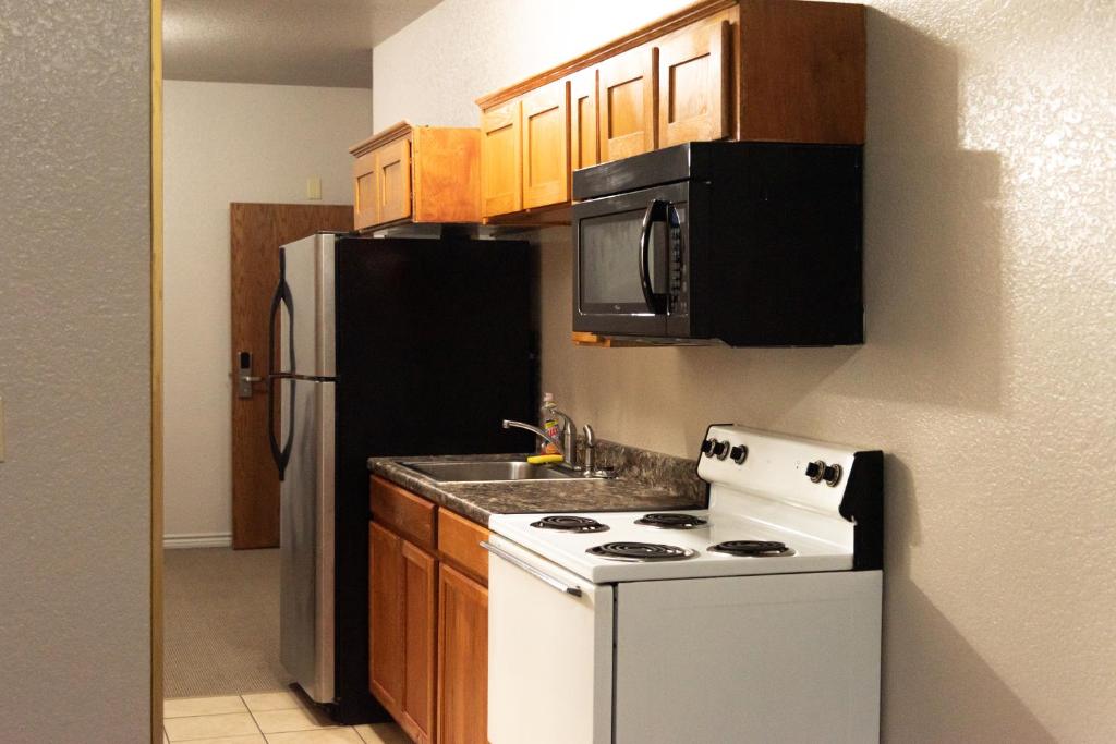 a kitchen with a white stove and a refrigerator at Premium Inn and Suites in Killeen