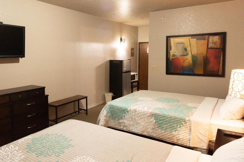a hotel room with two beds and a flat screen tv at Premium Inn and Suites in Killeen