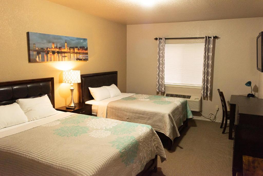 a hotel room with two beds and a window at Premium Inn and Suites in Killeen