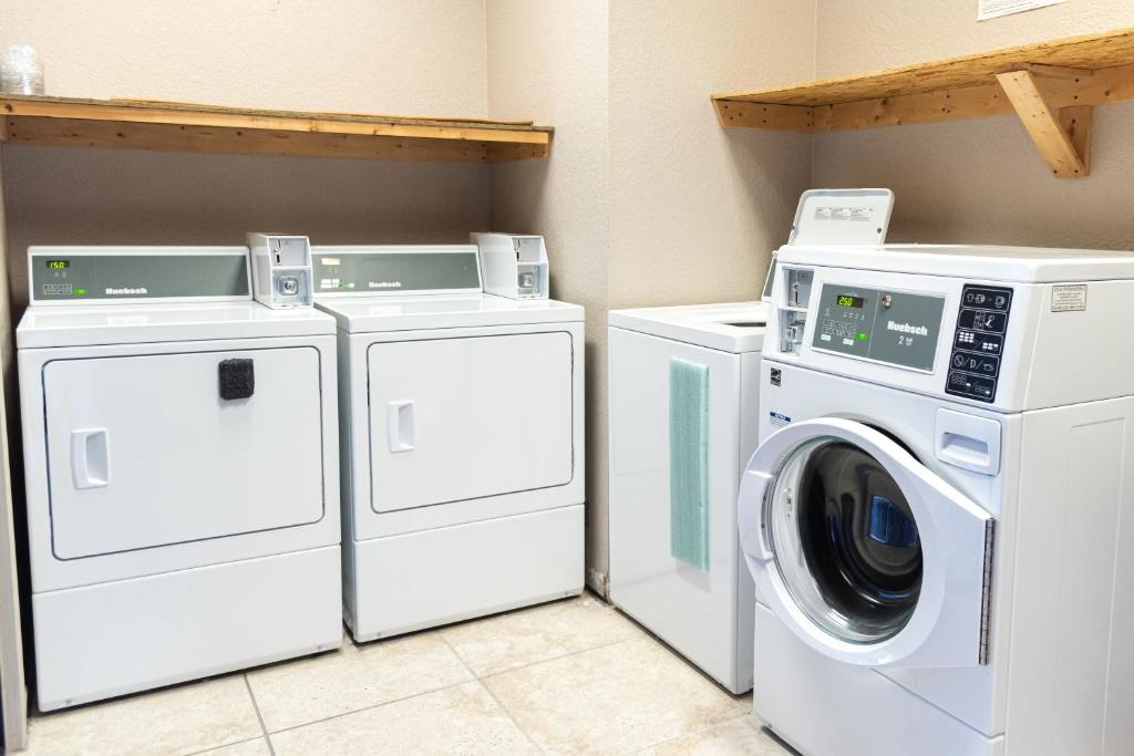two washing machines and a washer and dryer in a laundry room at Premium Inn and Suites in Killeen