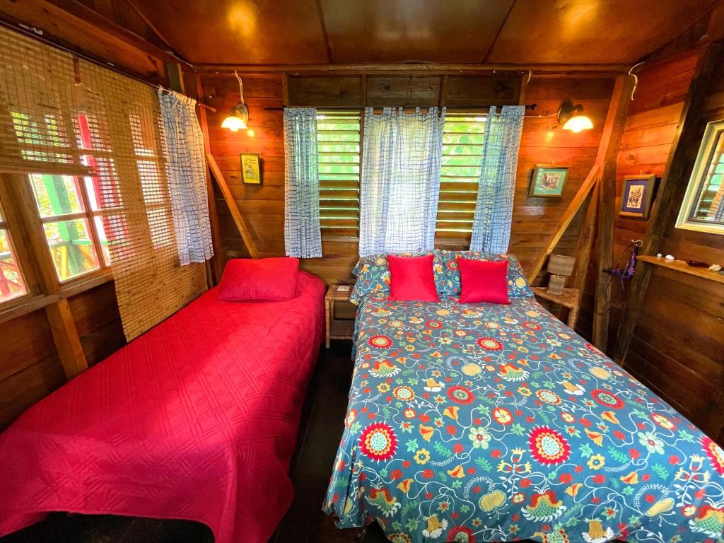 - une chambre avec 2 lits dans une petite maison dans l'établissement Judy House Cottages And Rooms, à Negril