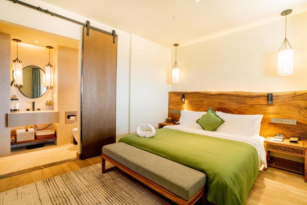 una camera con letto verde e un bagno di Jinling Onejoy Hotel a Nanjing
