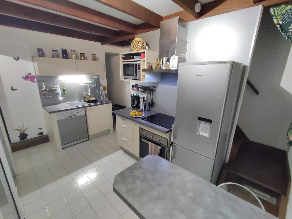 a kitchen with a refrigerator and a stove top oven at T2 à 300m de la plage in La Saline Les hauts 