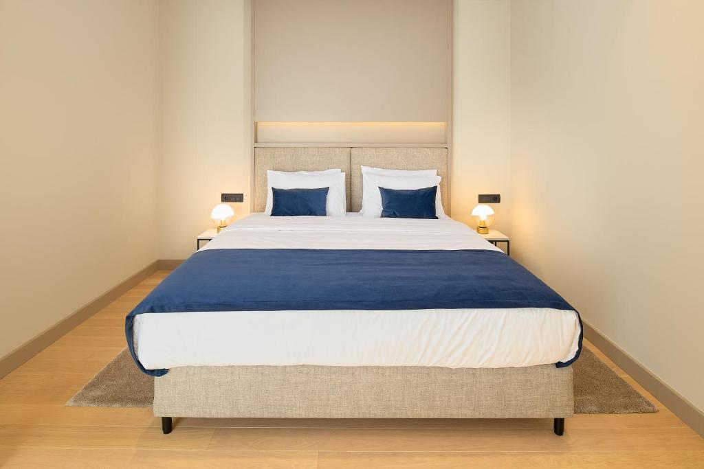 a bedroom with a large bed with blue pillows at Boutique Hotel Porto in Dubrovnik