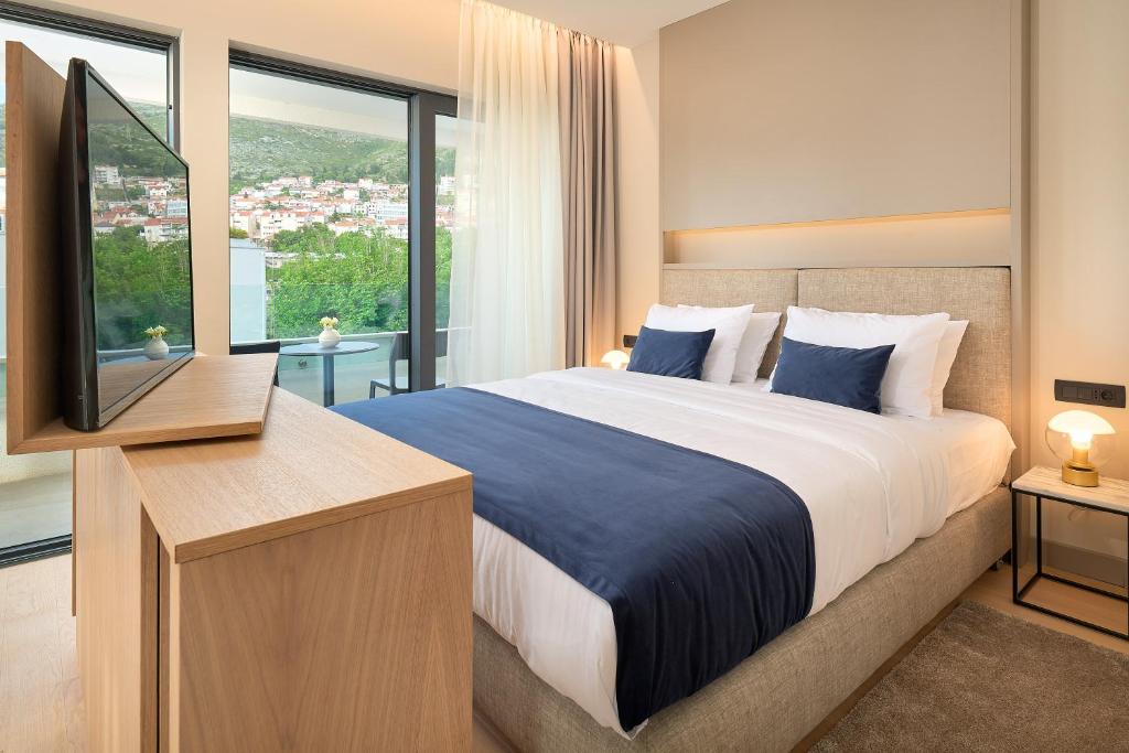a bedroom with a large bed and a television at Boutique Hotel Porto in Dubrovnik