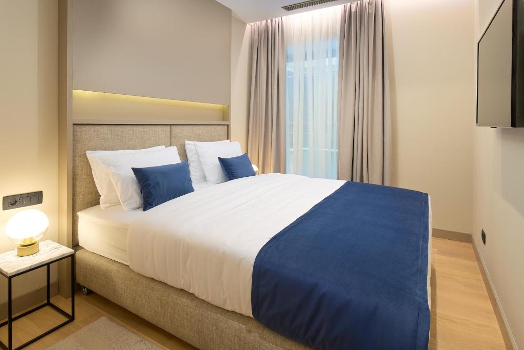 a bedroom with a large bed with blue and white pillows at Boutique Hotel Porto in Dubrovnik