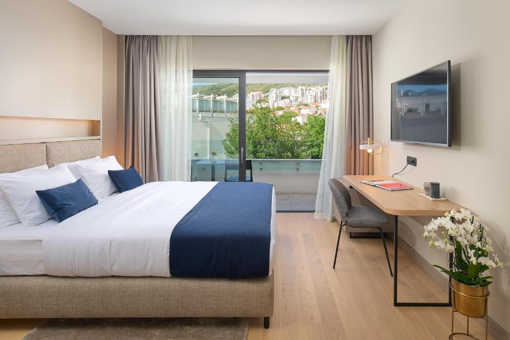 Cette chambre comprend un lit, un bureau et une fenêtre. dans l'établissement Boutique Hotel Porto, à Dubrovnik