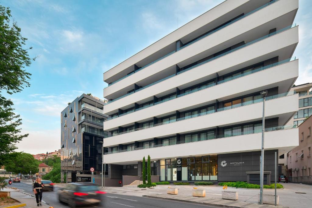 a tall white building on a city street at Boutique Hotel Porto in Dubrovnik