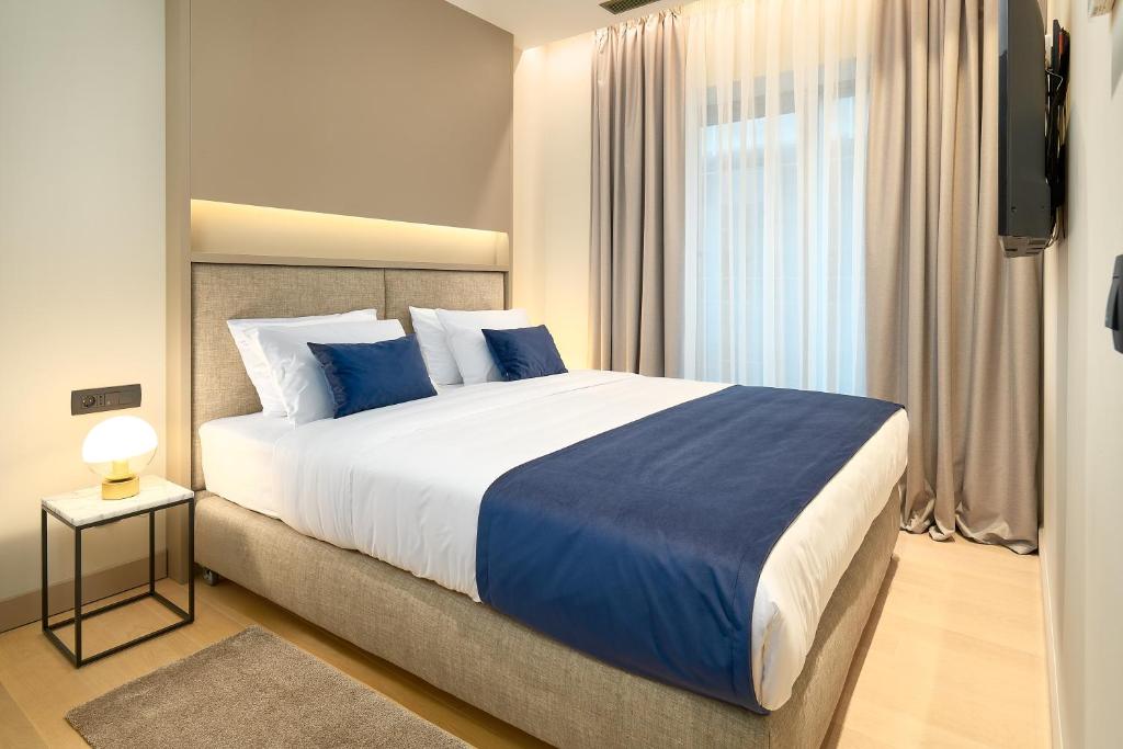 a bedroom with a large bed with blue pillows at Boutique Hotel Porto in Dubrovnik