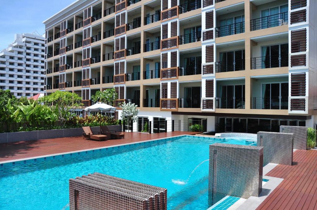 a swimming pool in front of a building at August Suites in Pattaya Central