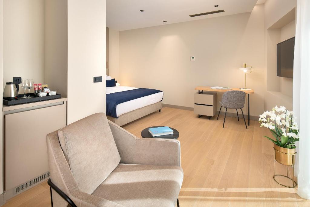 a hotel room with a bed and a chair and a desk at Boutique Hotel Porto in Dubrovnik