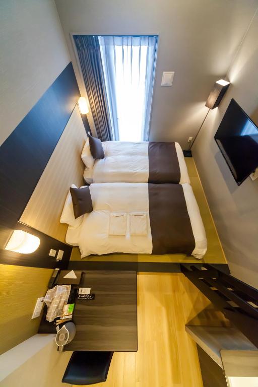 広島市にあるHOTEL SUITE HIROSHIMA YOKOGAWAのロフトベッドルーム(ベッド2台、窓付)