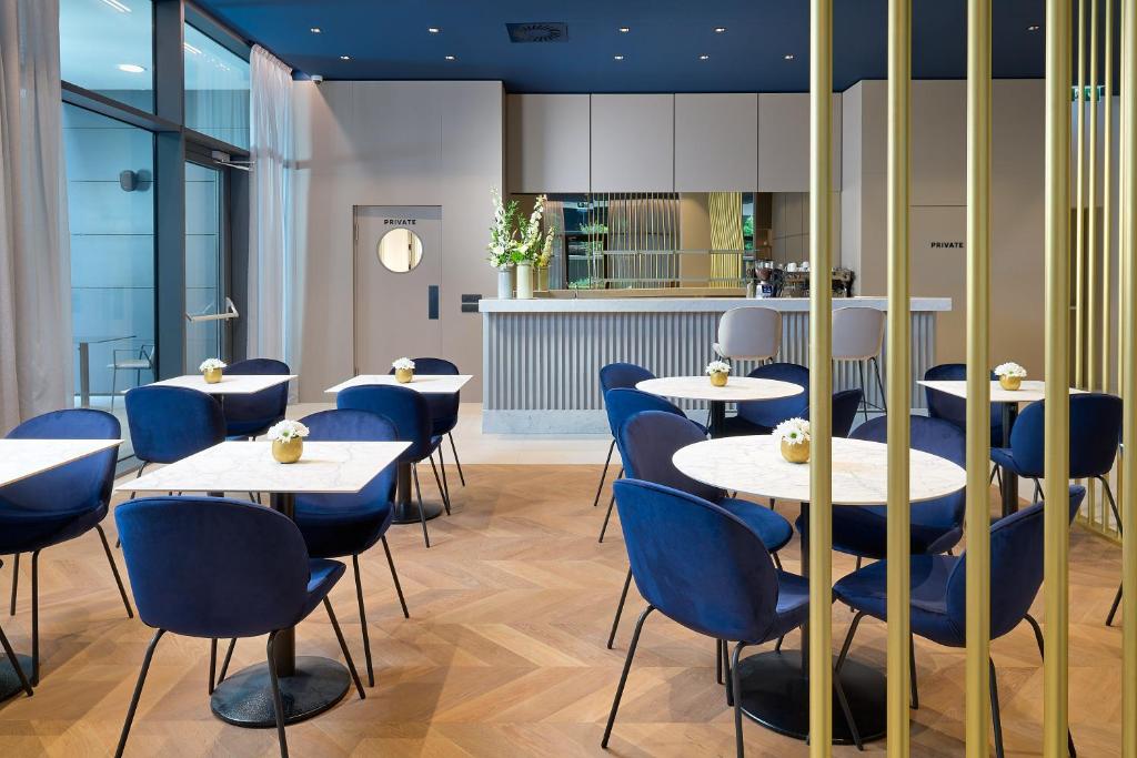 a restaurant with white tables and blue chairs at Boutique Hotel Porto in Dubrovnik
