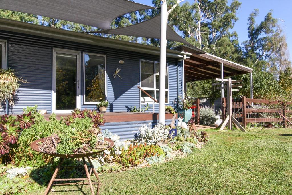 una casa azul con una mesa en el patio en Riverside Haven en Healesville