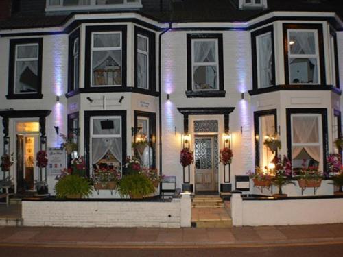 a white house with flowers in front of it at The Shrewsbury Guest House in Great Yarmouth