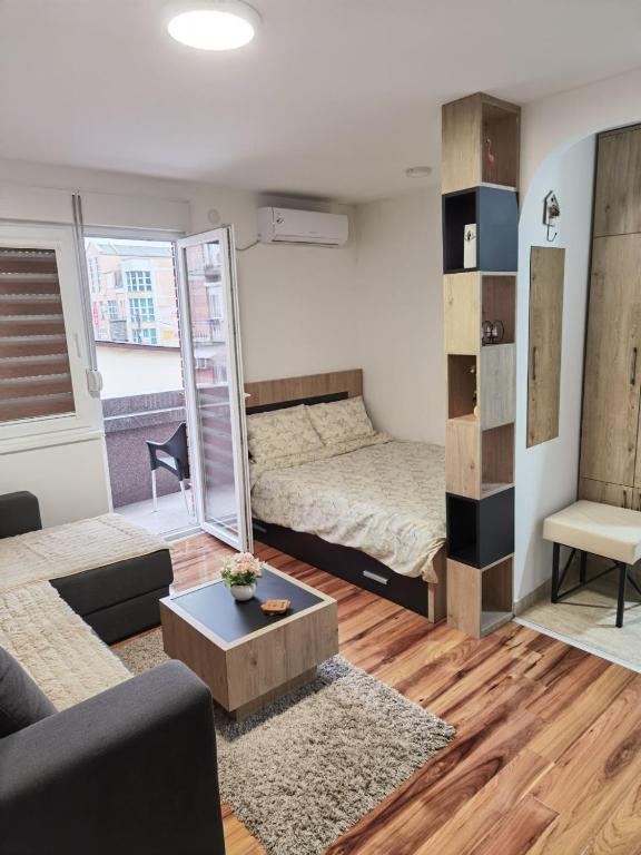 ein Wohnzimmer mit 2 Betten und einem Sofa in der Unterkunft Centar Milena in Aranđelovac