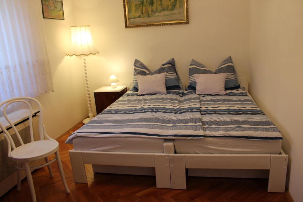 um quarto com uma cama com almofadas azuis e brancas em Centrum Apartman em Fonyód