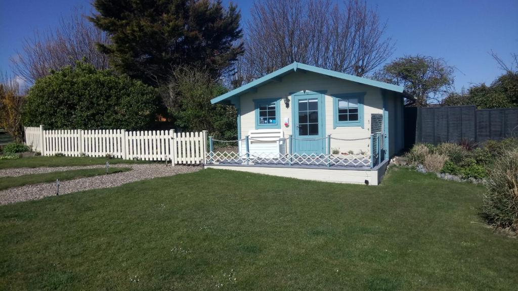 a small shed in a yard next to a fence at The cabin with the view in Overstrand