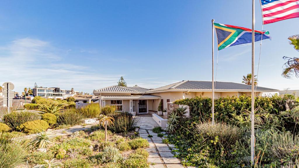 a flag flying in front of a house at The Sir David Boutique Guest House in Bloubergstrand