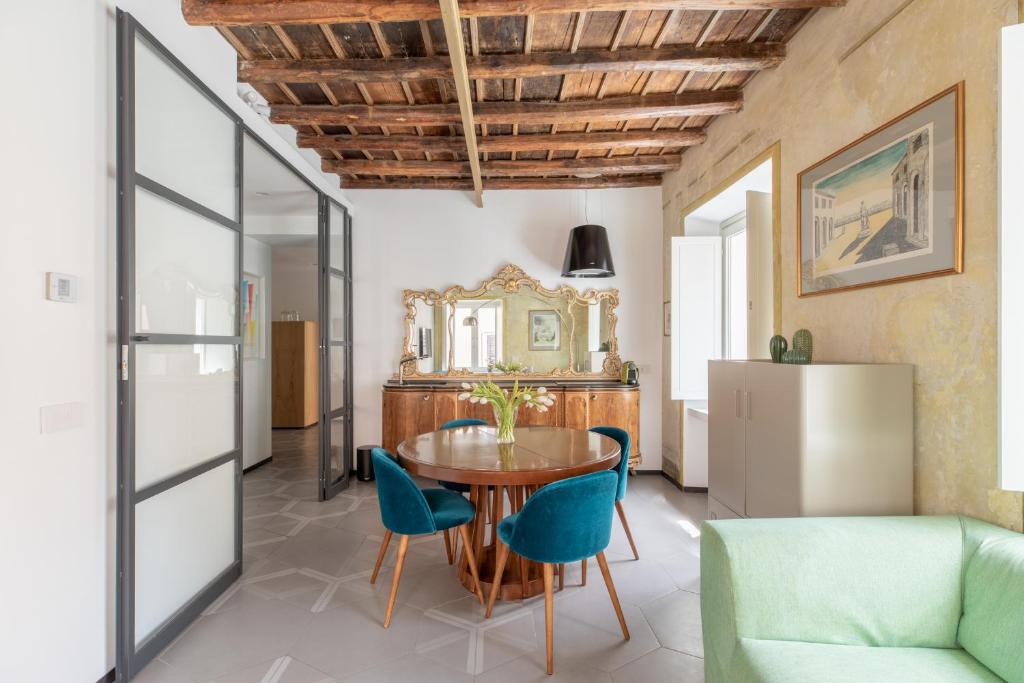 une salle à manger avec une table en bois et des chaises bleues dans l'établissement iFlat Vatican High-End Apartment, à Rome