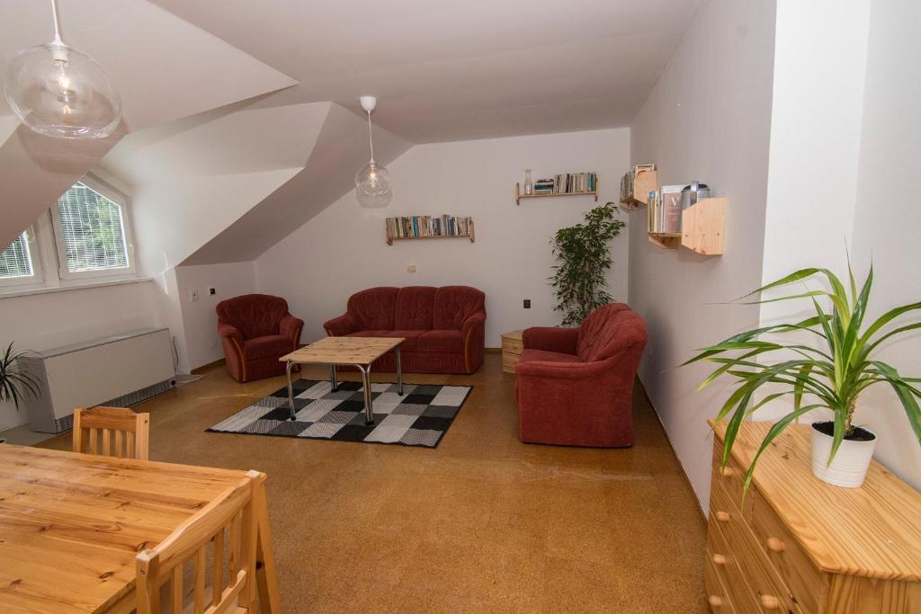sala de estar con sillas rojas y mesa en Apartmán Lorien Nekoř en Nekoř