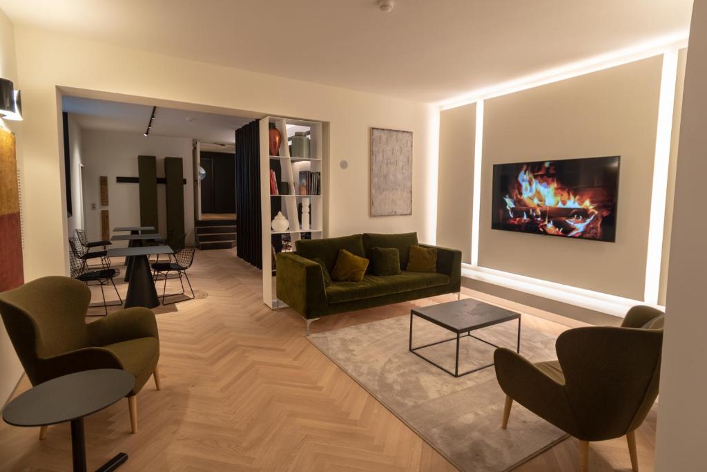Hotel La Terrazza RESTAURANT & SPA في أسيسي: غرفة معيشة مع أريكة خضراء وطاولة
