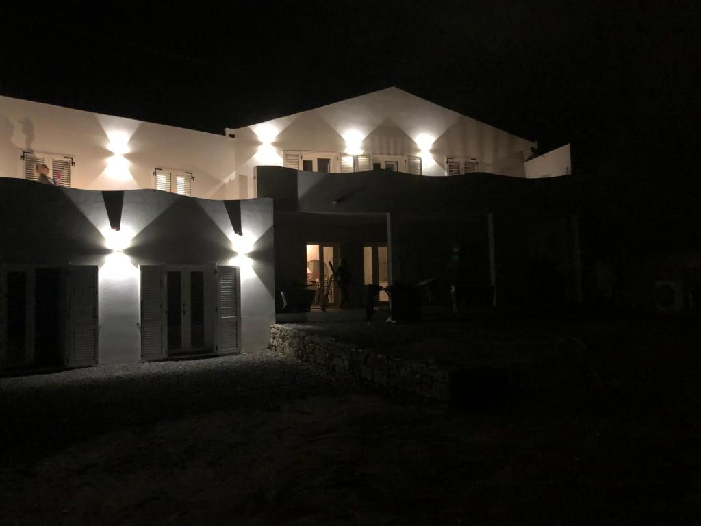 卡洛福泰的住宿－Luxury& Charme fronte mare Sardinia House7，夜晚有灯的白色房子