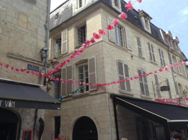 Um edifício com serpentinas cor-de-rosa à frente. em appartement coeur historique em Périgueux