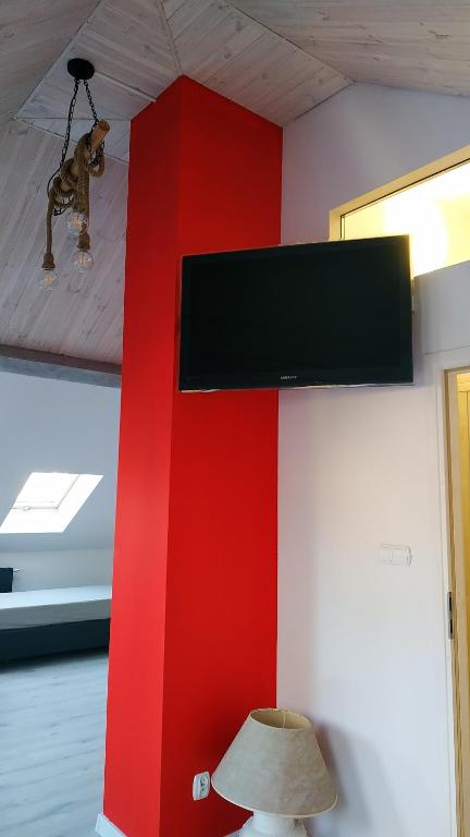 Televízia a/alebo spoločenská miestnosť v ubytovaní Apartament Witkacego Czerwony
