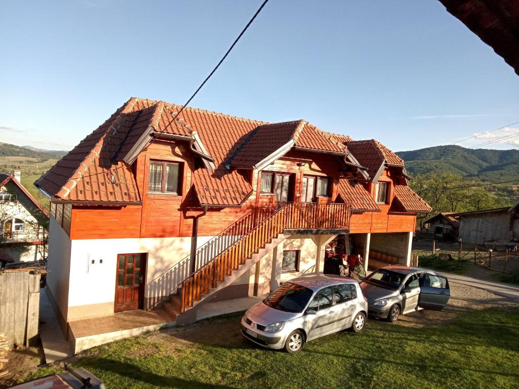 a house with two cars parked in front of it at Apartmani Bane in Kremna