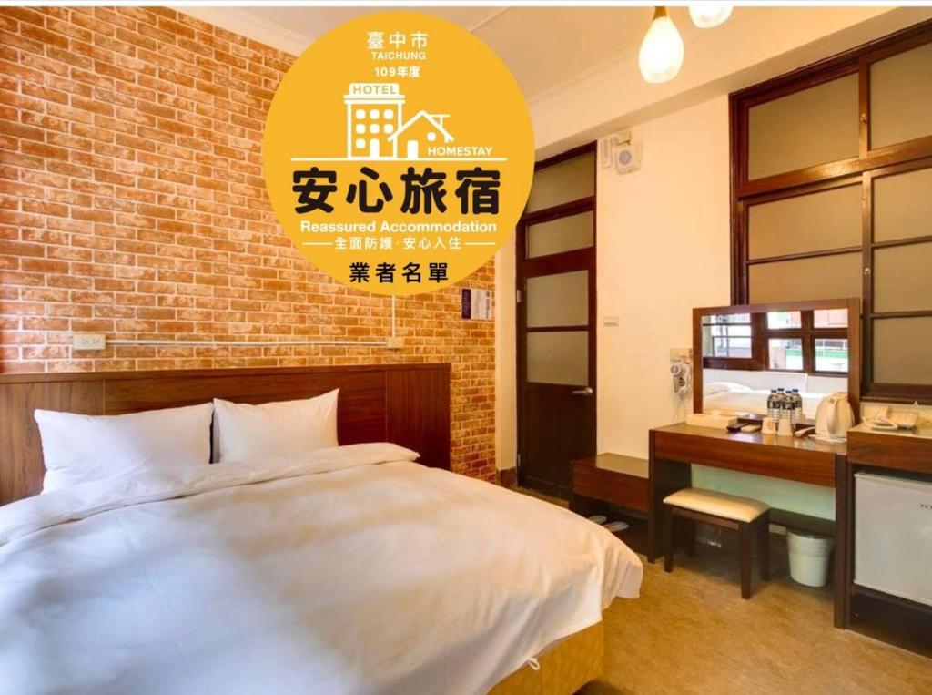 a bedroom with a bed and a brick wall at DC Hotel in Taichung