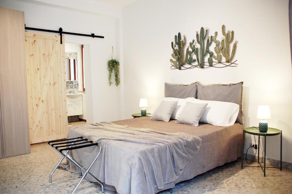 ein Schlafzimmer mit einem Bett mit einem Kaktus an der Wand in der Unterkunft BARI ROOMS Central Station in Bari