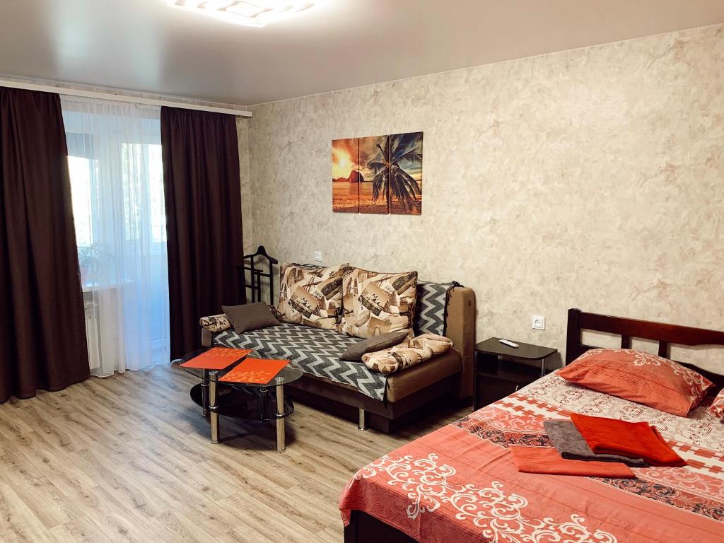 a hotel room with a couch and a bed at Apartment - Sobornyi Prospekt 97 in Zaporozhye