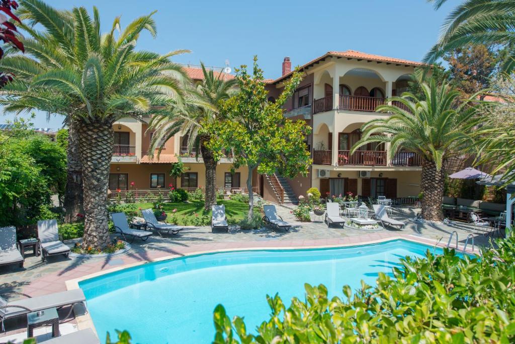 a view of the resort with a swimming pool and palm trees at Villa Pipini Luxury Studios in Limenas