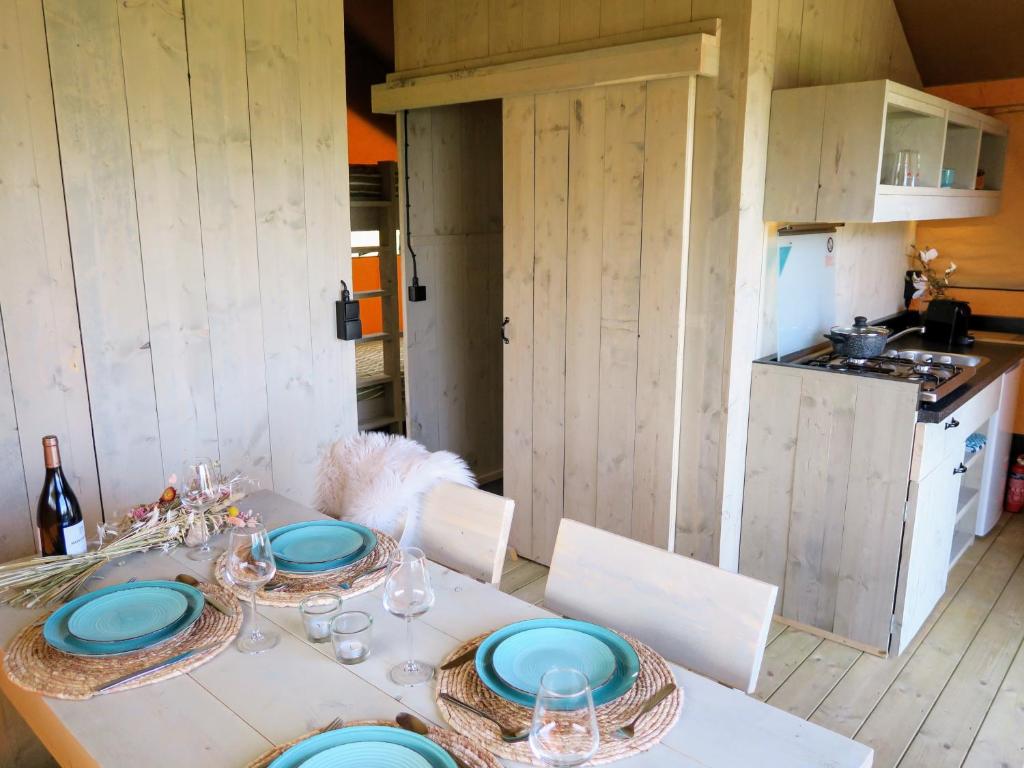 a table with blue plates on it in a kitchen at Luxe safaritenten Petit013 - nieuw in Tilburg