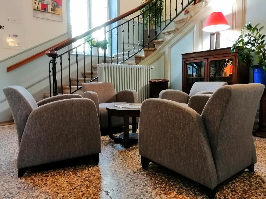 una sala de espera con sillas, mesa y escaleras en VTF Le Domaine Les Hautannes, en Saint-Germain-au-Mont-dʼOr