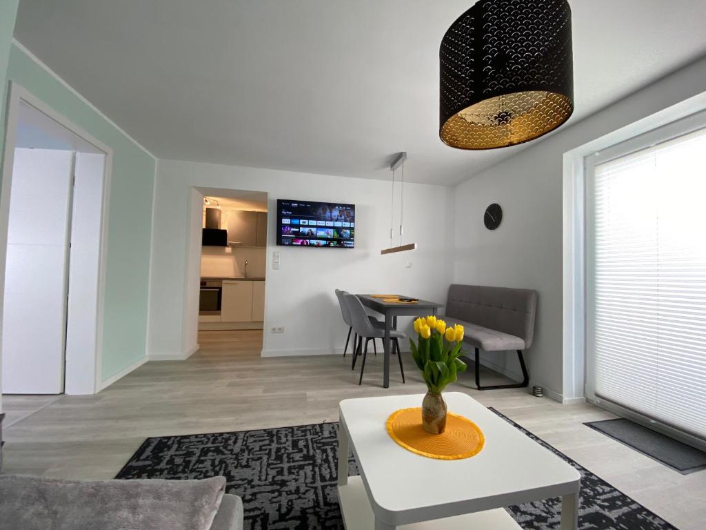 a living room with a vase of flowers on a table at Henning 1 in Kirchdorf