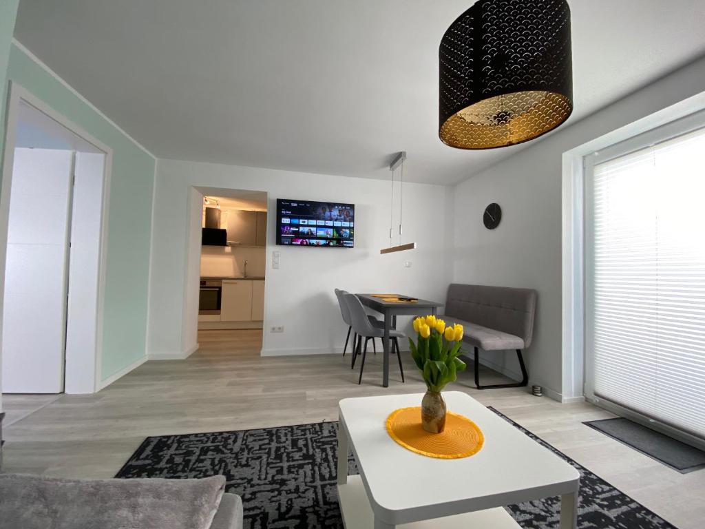 ein Wohnzimmer mit einer Vase mit Blumen auf einem Tisch in der Unterkunft Henning 1 in Kirchdorf