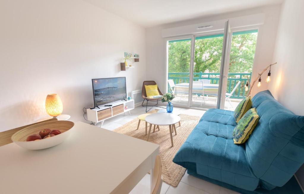 sala de estar con sofá azul y TV en Natsuocean, en Vieux-Boucau-les-Bains