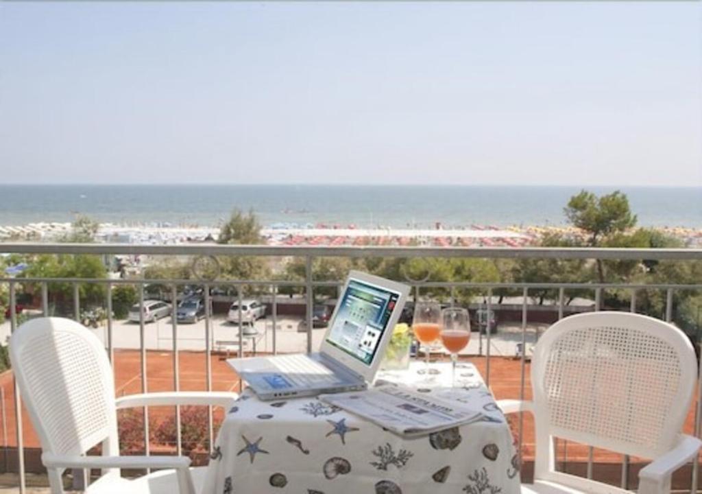 un ordenador portátil sentado en una mesa en un balcón en Hotel Nizza - SeaView BeachFront Park Hotel, en Riccione