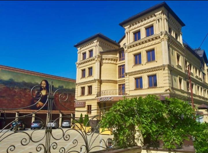 un grand bâtiment avec une fresque murale sur son côté dans l'établissement Grand Hotel Classic, à Armavir